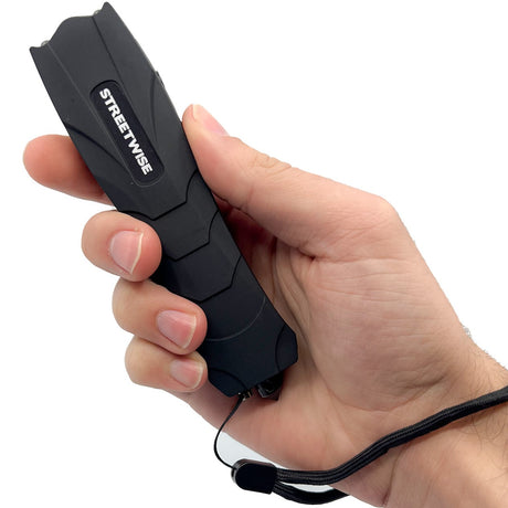 A hand holding a black Streetwise Serpent LED Glass Breaker Stun Gun 83M