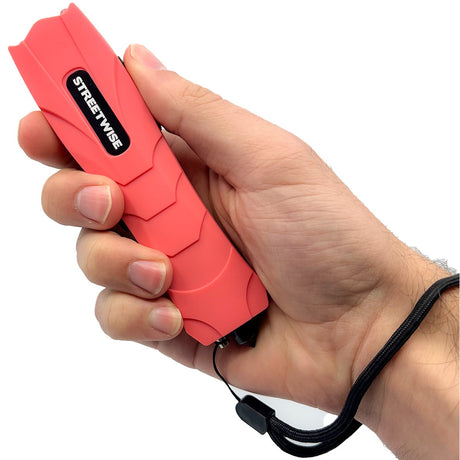 A hand holding a red Streetwise Serpent LED Glass Breaker Stun Gun 83M