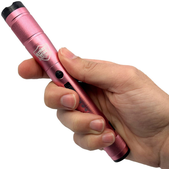 A hand holding a pink streetwise streetlight LED flashlight.