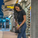 a woman placing a TASER Bolt 2 Self-Defense Compact Reloadable Shooting Stun Gun in her bag