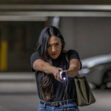 a woman pointing a TASER Bolt 2 Self-Defense Compact Reloadable Shooting Stun Gun