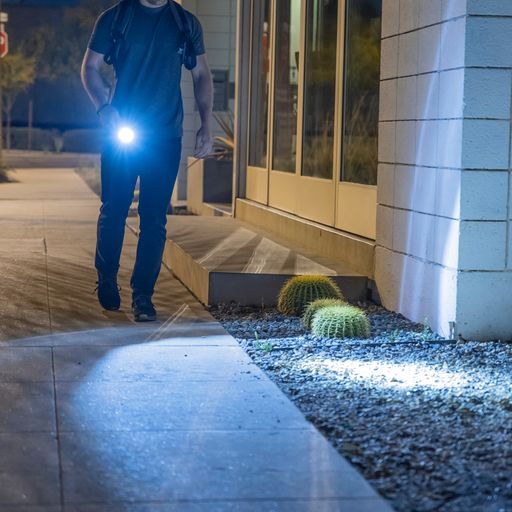 a photo of a man holding a TASER Strikelight 2 Rechargeable Stun Gun Flashlight white with its flashlight on