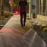 a man holding a white TASER Strikelight 2 Rechargeable Stun Gun Flashlight with the red light on