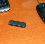 Black Voice Activated USB Drive Voice Recorder on a brown table
